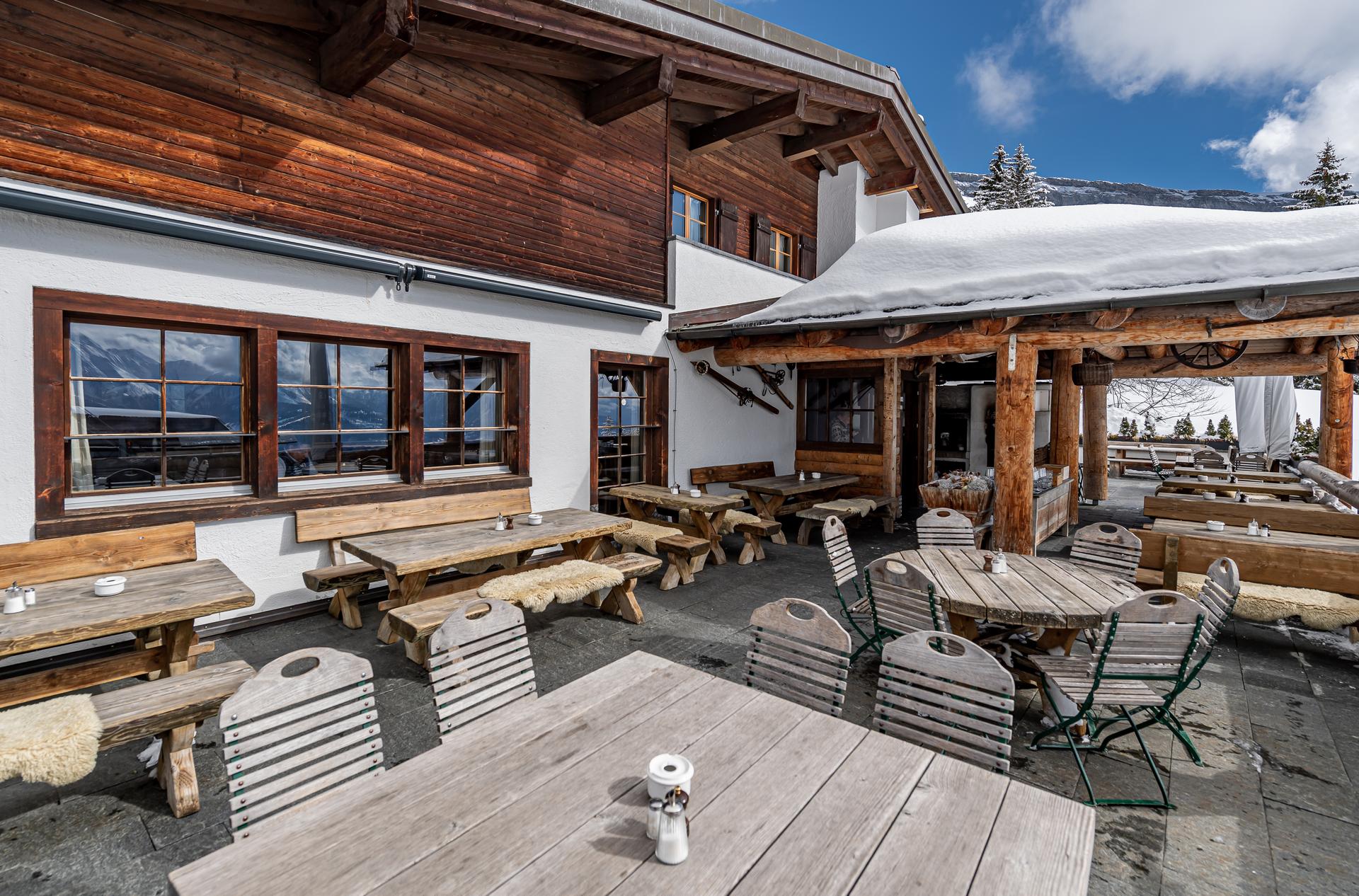 terrasse mit stühlen und tischen außenbereich im bergrestaurant ustria startgels flims restaurants in den bergen